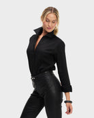 Woman wearing a black shirt and black pants on a white background